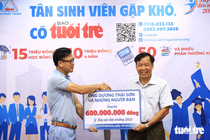 'Cánh tay nối dài' tiếp sức đến trường cho tân sinh viên khó khăn - Ảnh 1. Ông Dương Thái Sơn - giám đốc Công ty TNHH bao bì giấy Nam Long (phải) - đến báo Tuổi Trẻ trao khoản đóng góp của ông và bạn bè, đồng nghiệp cho chương trình "Tiếp sức đến trường" - Ảnh: VŨ THỦY