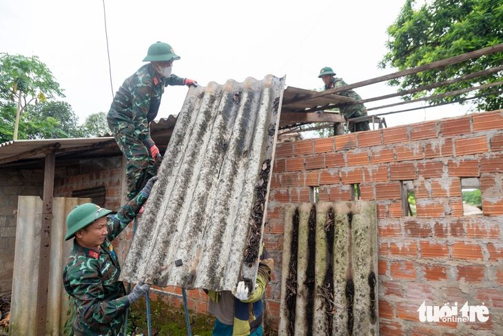 Bộ đội giúp dân di dời nhà cửa, sớm bàn giao mặt bằng cao tốc Cam Lộ - Vạn Ninh- Ảnh 1. Bộ đội Trung đoàn 9 giúp đỡ người dân di dời tài sản đến nơi ở mới, bàn giao mặt bằng cho dự án - Ảnh: HOÀNG TÁO