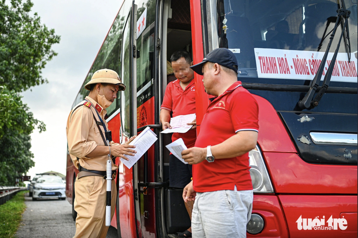 Bộ Công an đề xuất phạt tới 12 triệu đồng với tài xế ô tô dùng bằng lái bị trừ hết điểm- Ảnh 1. Cảnh sát giao thông kiểm tra một phương tiện - Ảnh: HỒNG QUANG