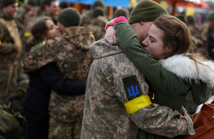Bộ Quốc phòng Ukraine kêu gọi toàn dân 'quên cuộc sống yên bình' để đánh bại Nga- Ảnh 1. Một phụ nữ Ukraine ôm tạm biệt bạn trai trước khi anh này ra tiền tuyến vào tháng 3-2022 - Ảnh: REUTERS